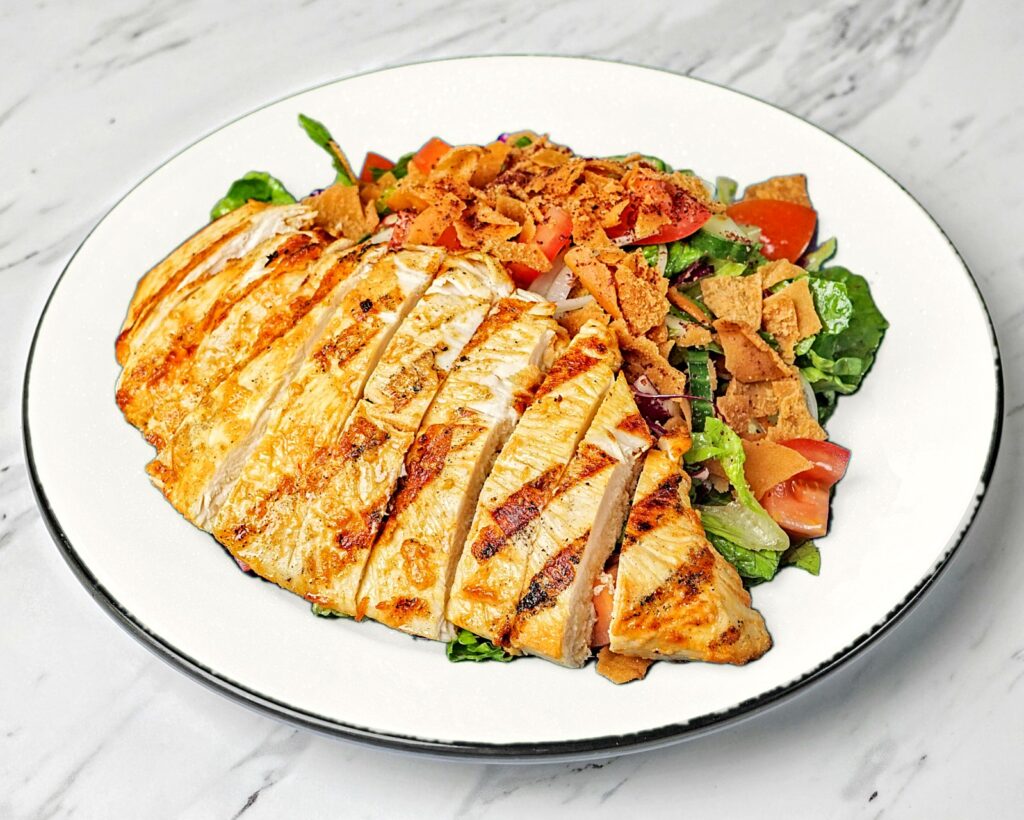 Fattoush salad topped with grilled chicken